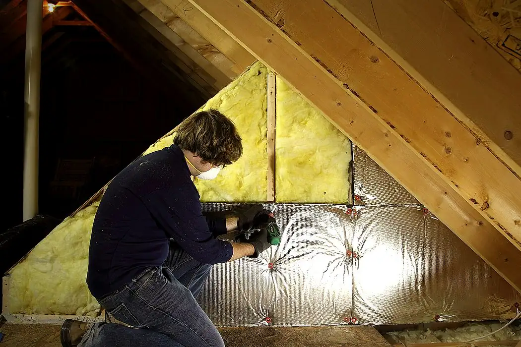Pose d'isolant sous la toiture dans des combles